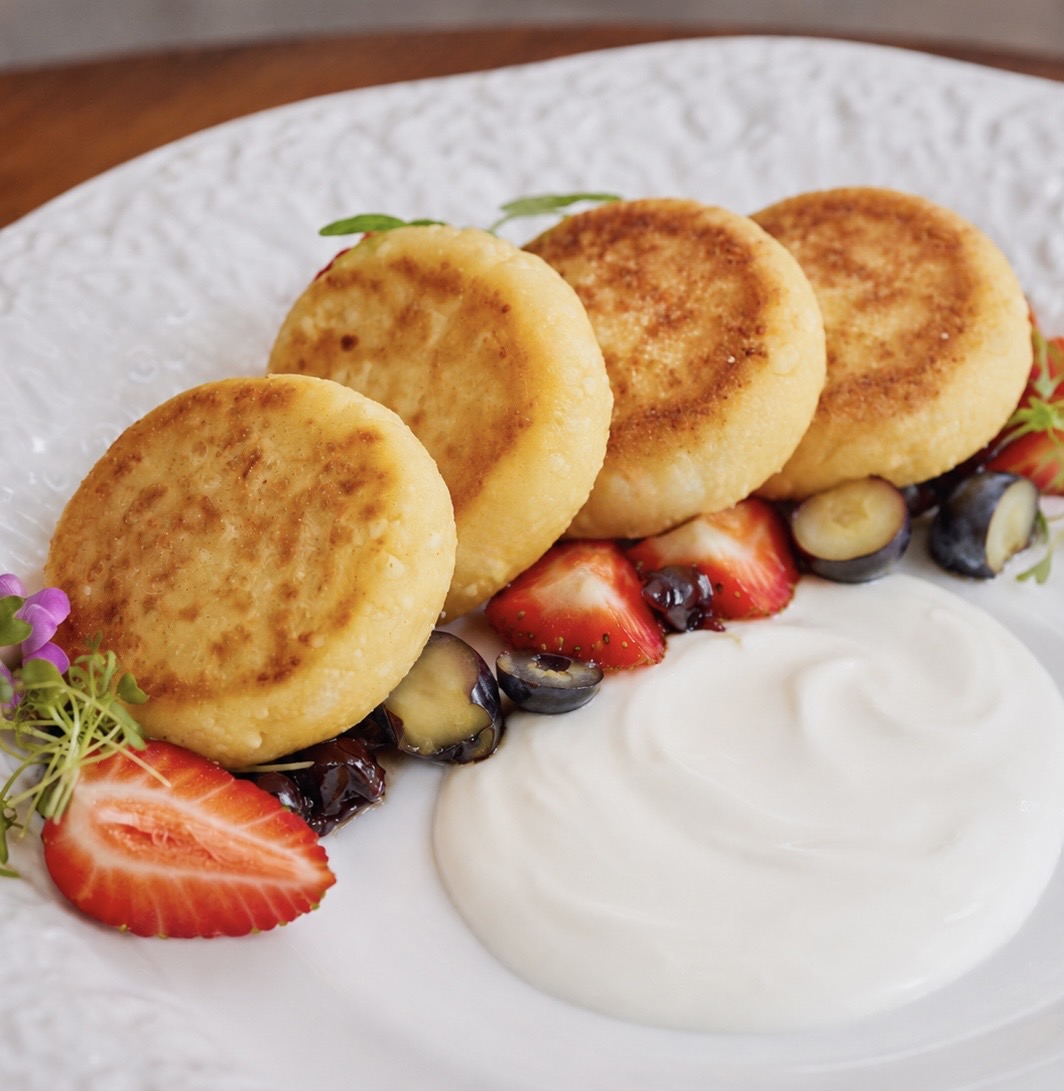 Homemade syrniki with berries and sour cream