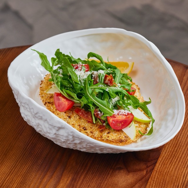 Milanese schnitzel with green apple and arugula